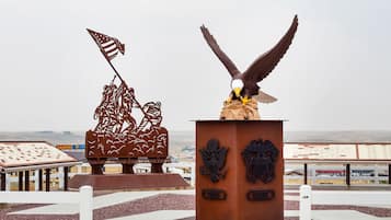 Eine Adlerstatue mit einer Flagge, eine Baumskulptur und im Hintergrund ein Gebäude mit einem Kasino-Schild.