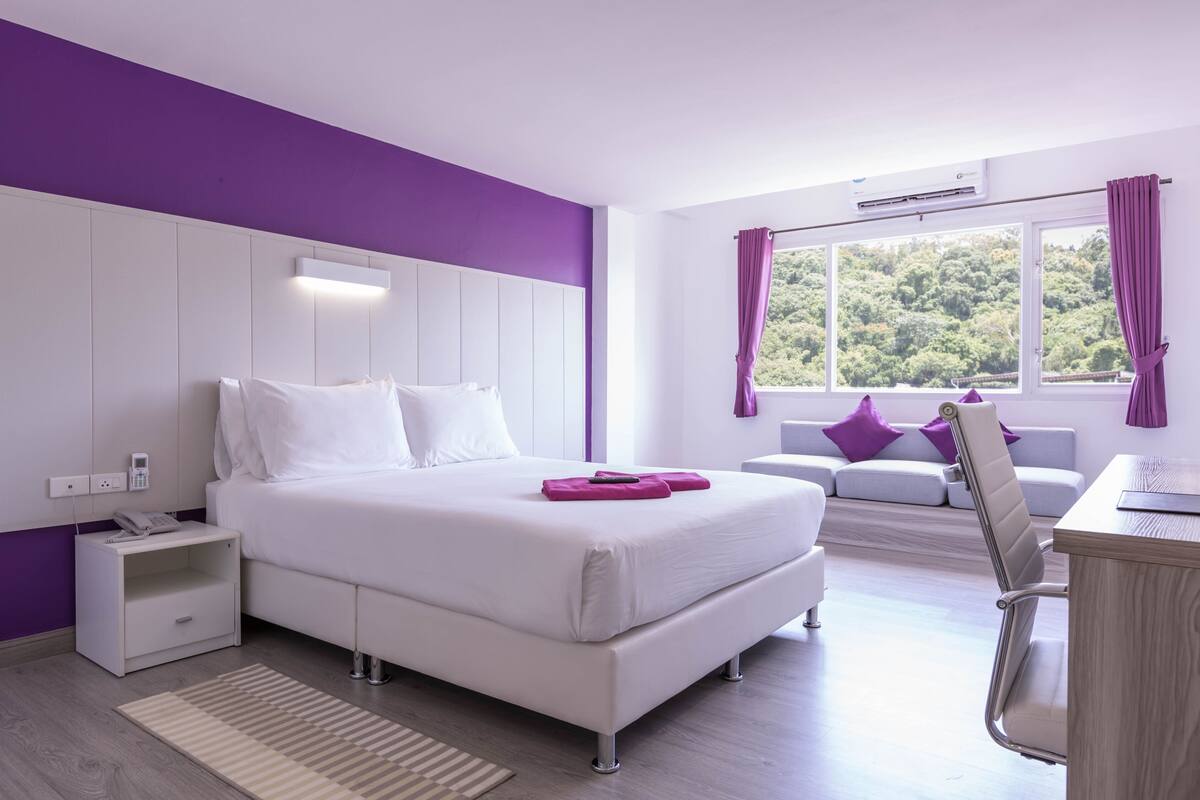 Un dormitorio moderno con una cama grande, una mesita de noche y un escritorio con silla.