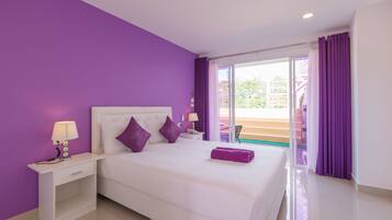 Camera d'albergo con un letto grande, tende viola e vista sull'esterno.