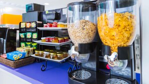 A coffee machine with two dispensers filled with granola and coffee beans. - Hotel Zing (Pattaya)