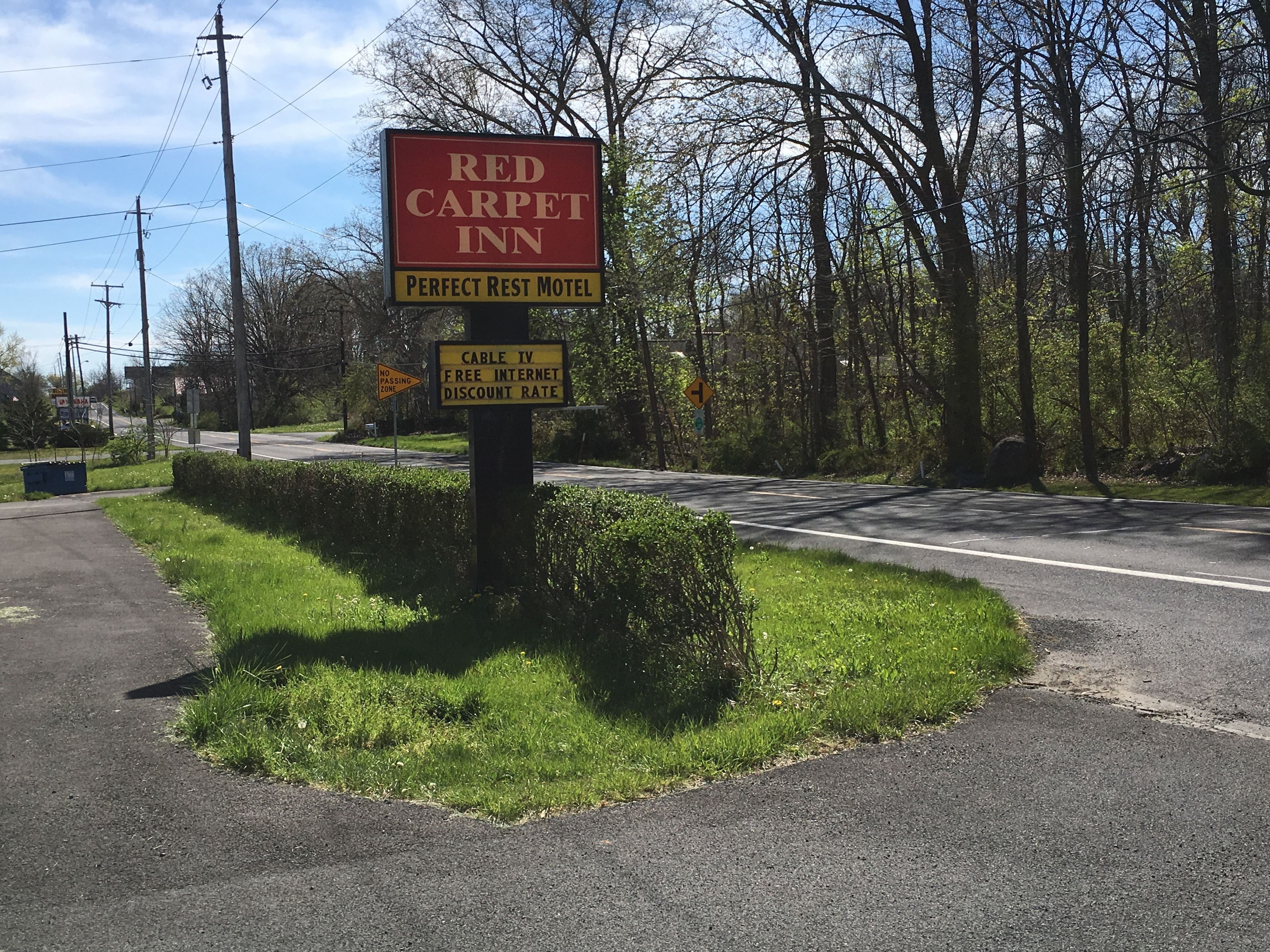 A sign for Red Carpet Inn, a motel with a cable TV and free internet discount rate.