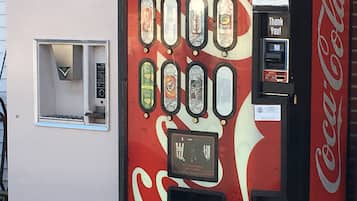 Máquina expendedora vintage de Coca-Cola con varias opciones de bebidas, ranura para monedas y un letrero que dice 'Gracias'.