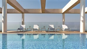 A pool area with lounge chairs and a view of the sea. - The Ritz-Carlton, Herzliya (Herzliya)