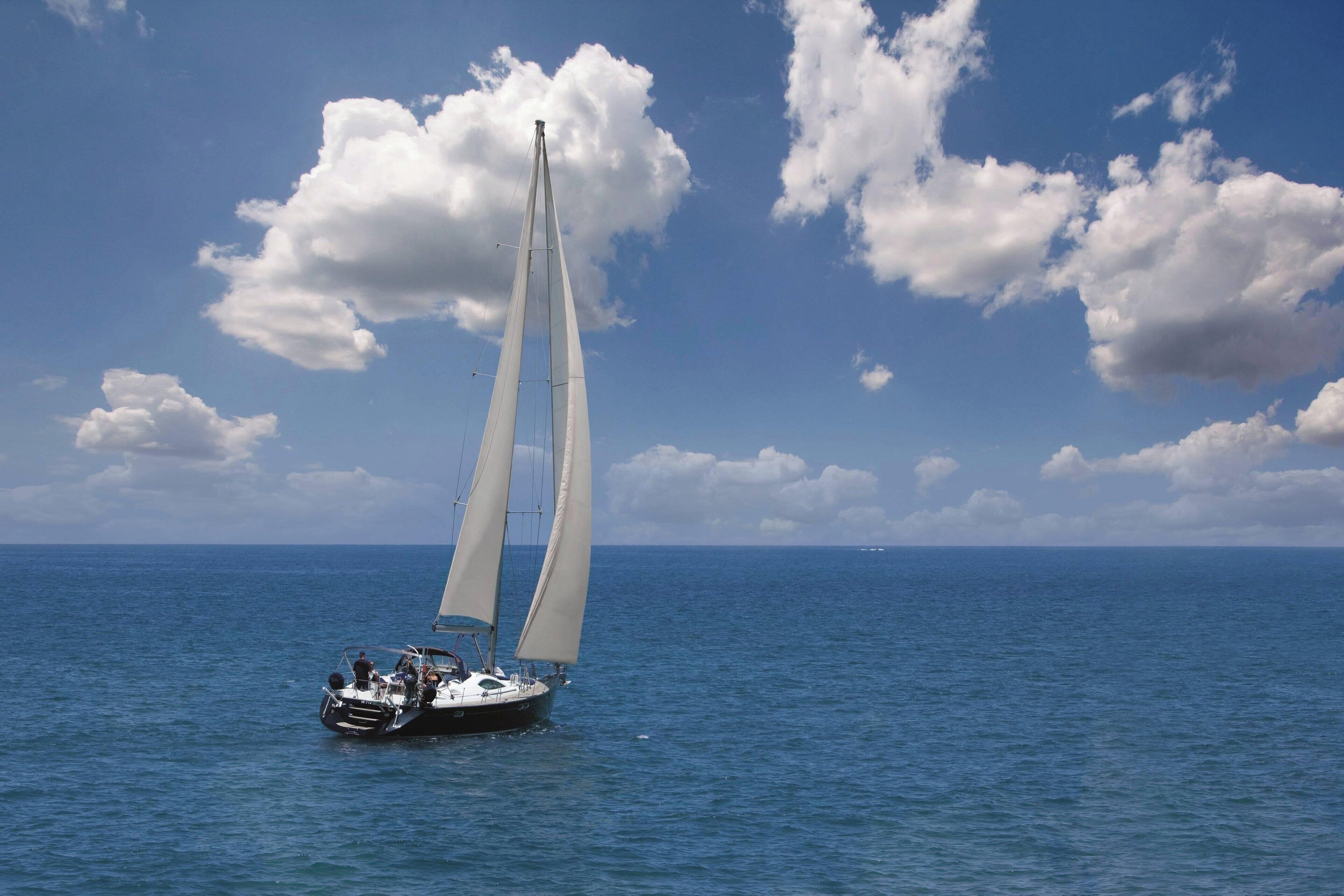Un velero en un mar tranquilo con cielo despejado.