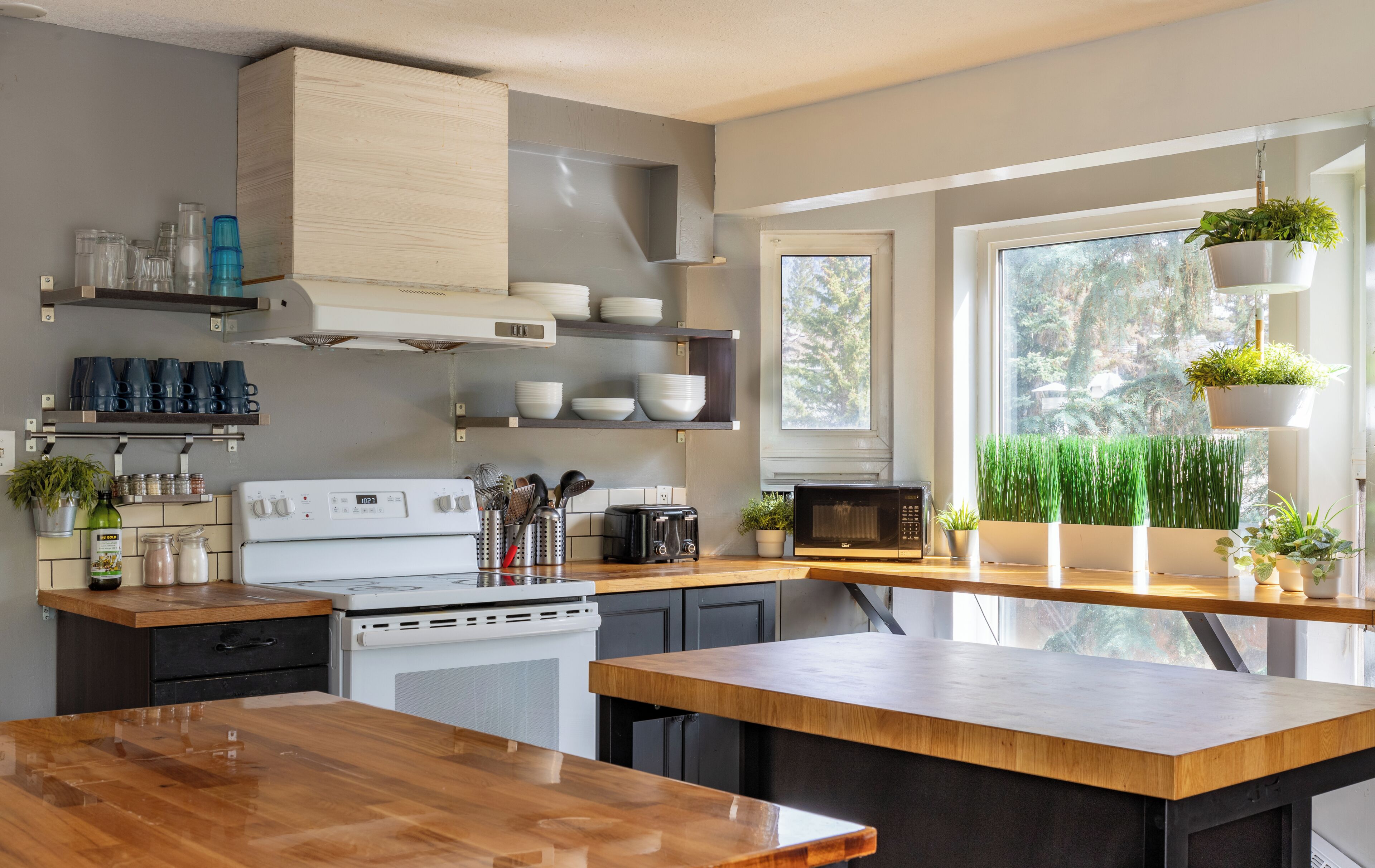 Une cuisine moderne avec un plan de travail en bois, une cuisinière blanche et divers appareils de cuisine.