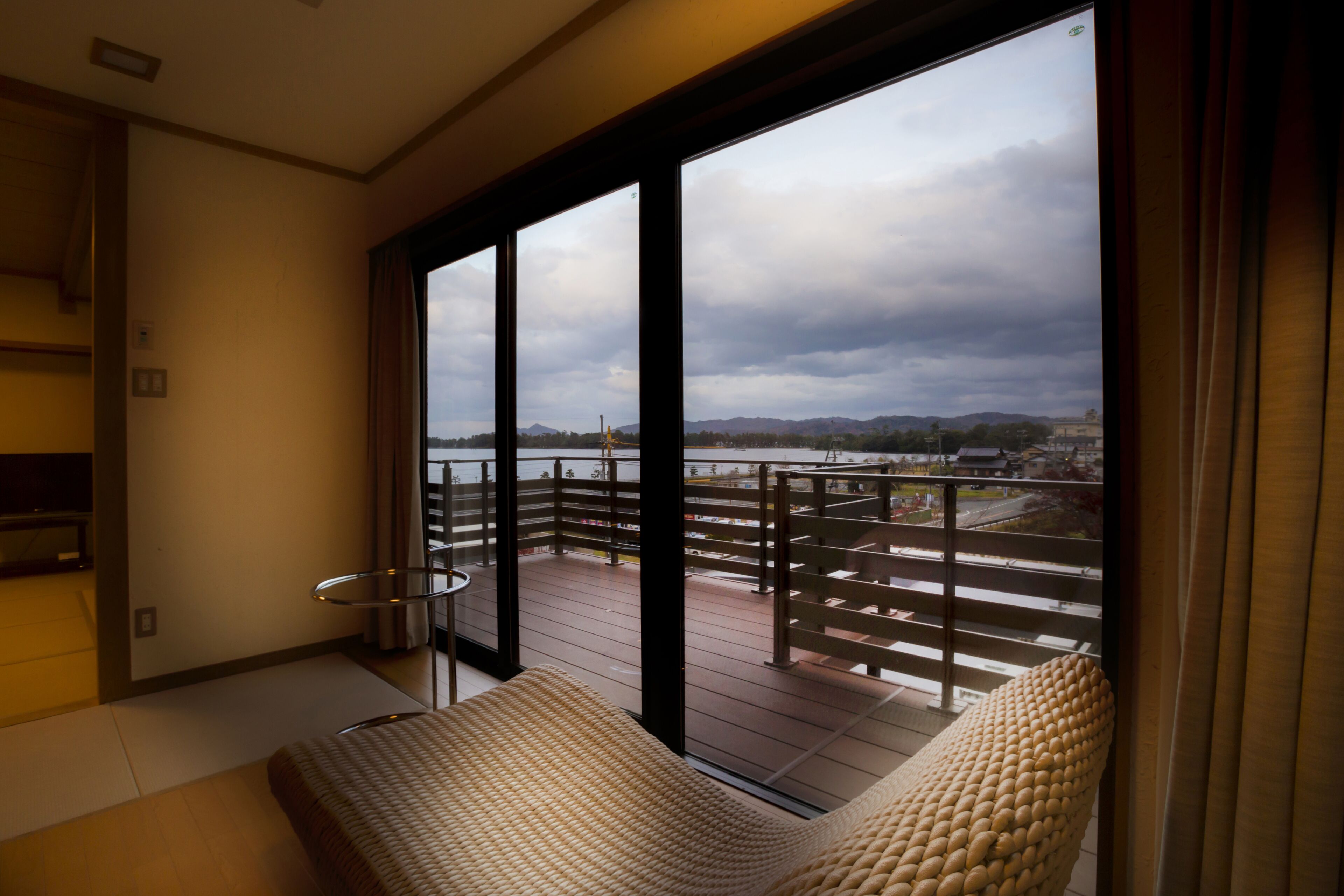A balcony with a view of a bridge and mountains.