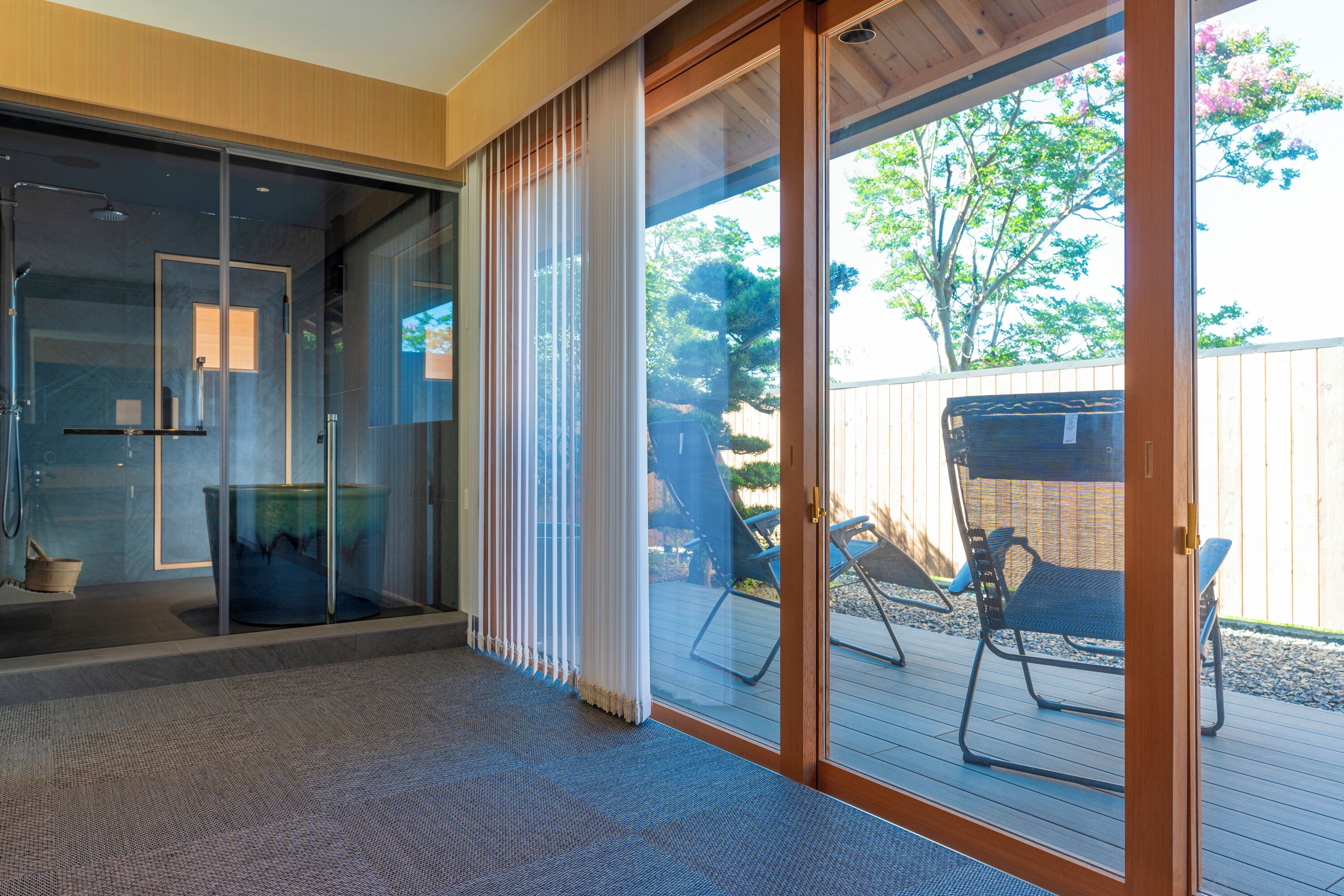 A modern interior with a glass door leading to an outdoor deck.