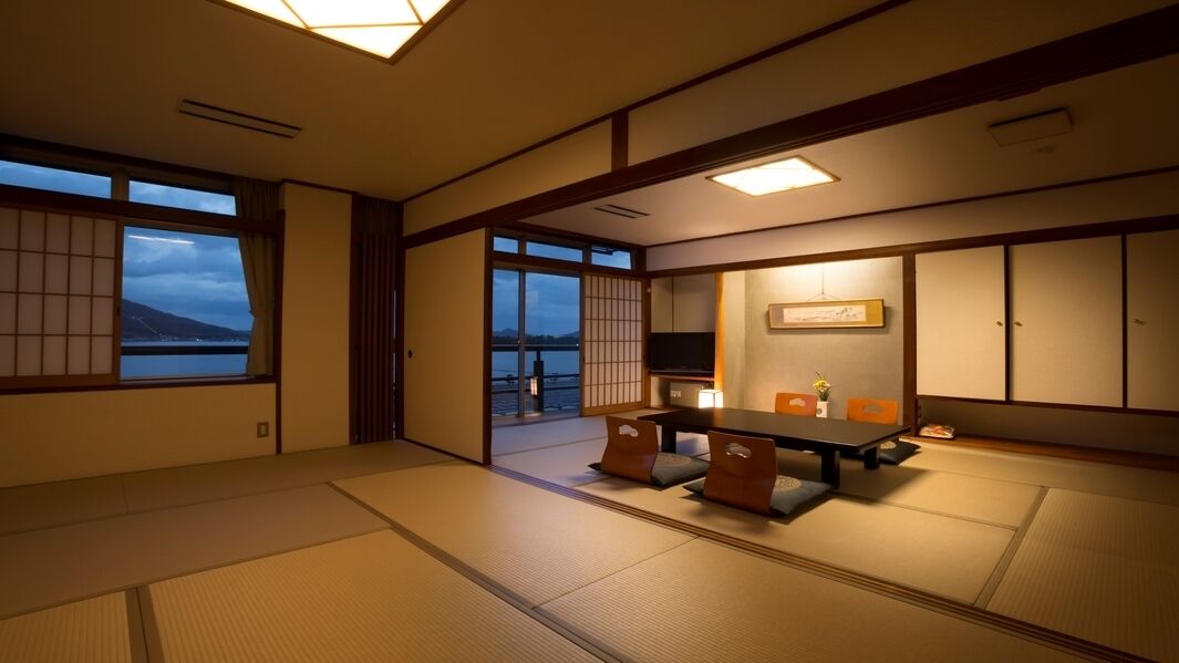 A traditional Japanese room with tatami flooring, sliding doors, and a low table with cushions.