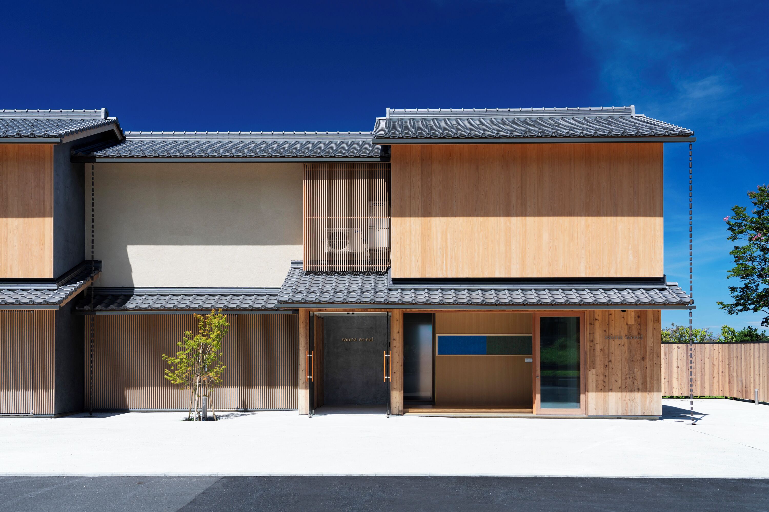 A traditional Japanese building with a wooden exterior, a tiled roof, and a sliding door entrance.