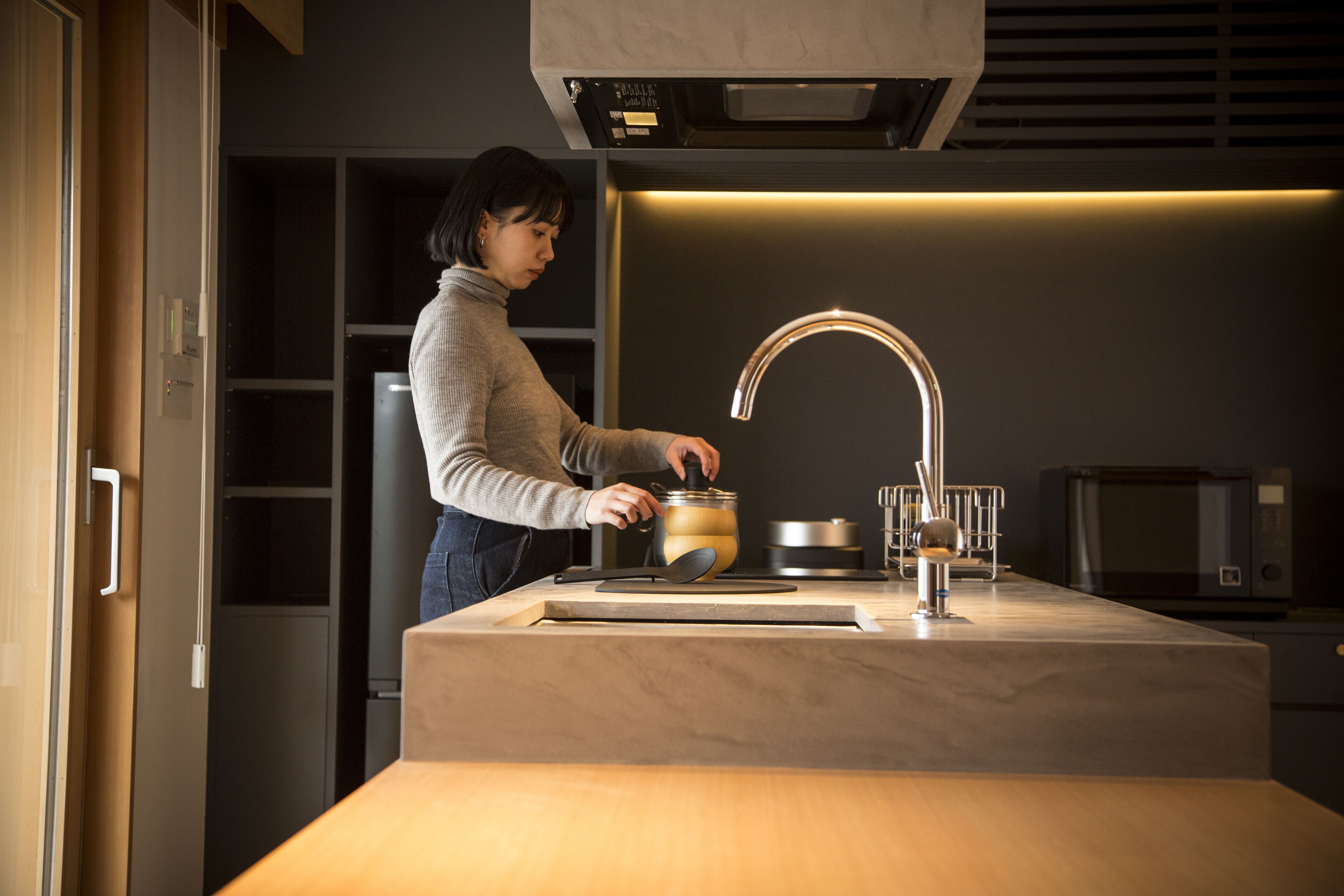 A modern kitchen with a built-in stove, a sink, and a microwave.