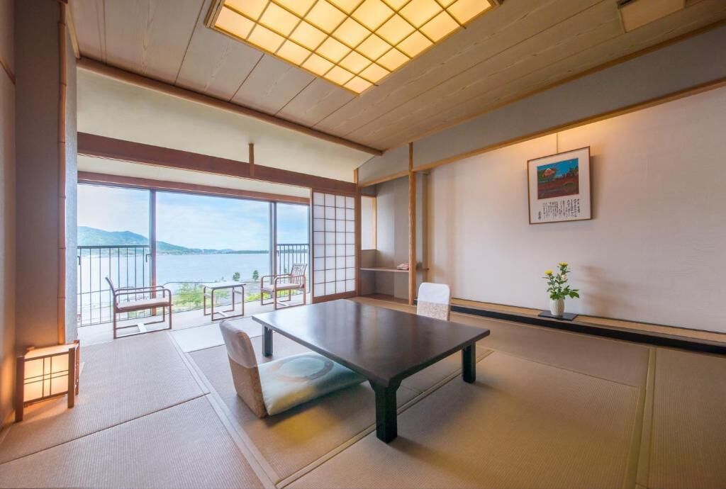 Et traditionelt japansk værelse med tatamimåtter, et lavt bord og udsigt til havet.