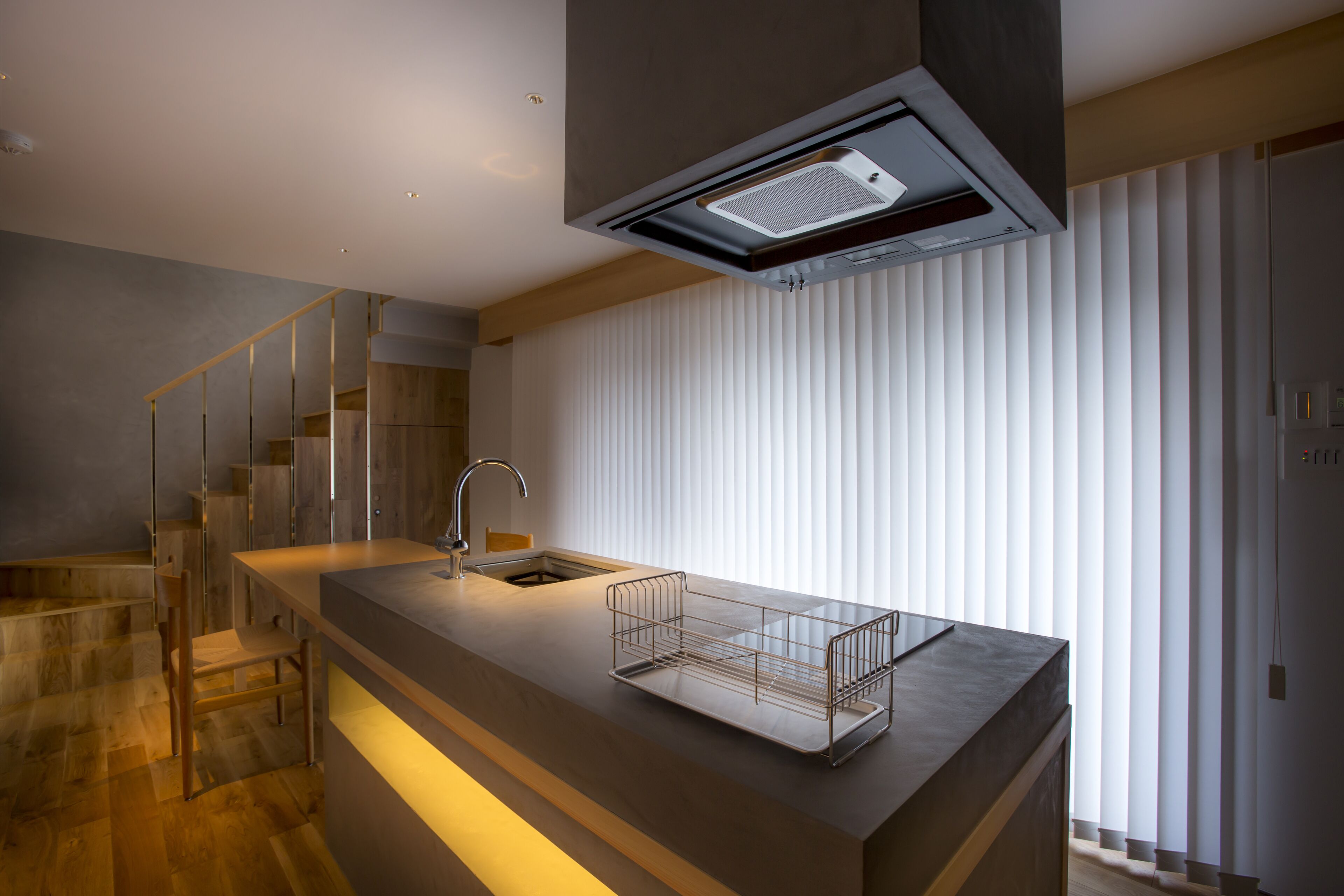 Een moderne keuken met een houten aanrecht, een ingebouwde spoelbak en een roestvrijstalen afzuigkap.