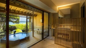 Un moderno espacio de spa con una bañera de hidromasaje, terraza de madera y vistas al mar.