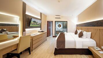 A hotel room with a bed, desk, chair, and a TV mounted on the wall.