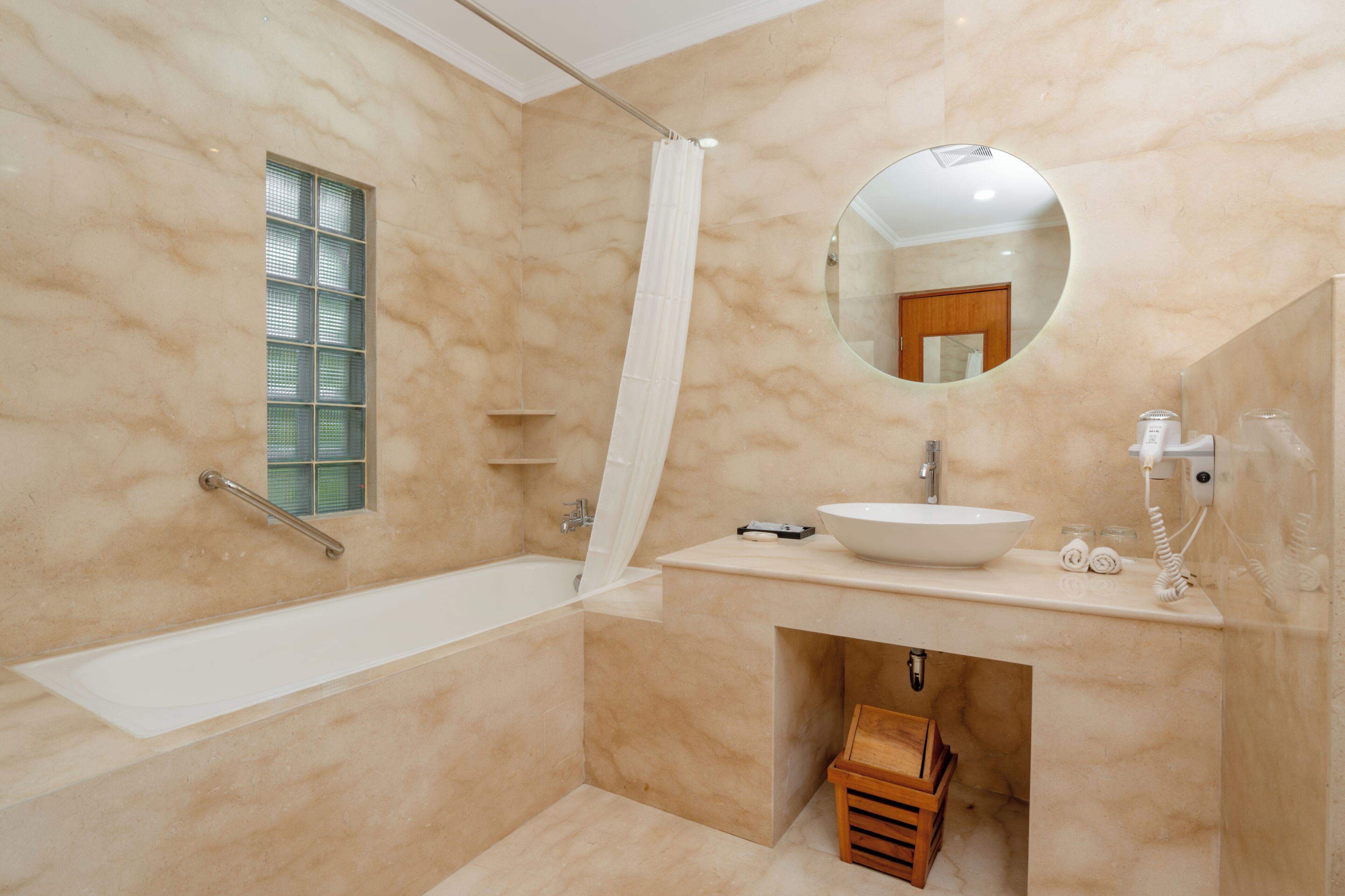 A modern bathroom with a bathtub, a sink, a mirror, and a shower curtain.