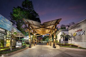 A covered outdoor area with a wooden structure, signage for a bar, and a parking sign. - Grand Istana Rama Hotel (Kuta)