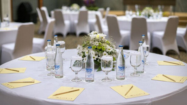 A round table with white tablecloths, white chairs, and a floral centerpiece. - Grand Istana Rama Hotel (Kuta)