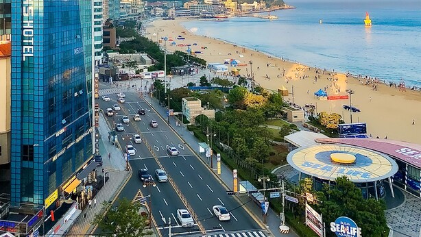 Eine Stadtansicht mit Strand, einem Hotel namens 'Hotel Michael' und einem Busan-Meereslebens-Aquarium.