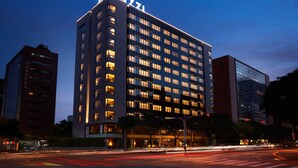 Un hotel de varios pisos con ventanas iluminadas y un cartel llamativo en la parte superior.