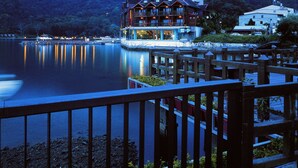 A lakeside lodge with a wooden deck and a view of the lake. - LEALEA GARDEN HOTEL SUN MOON LAKE (Yuchi)