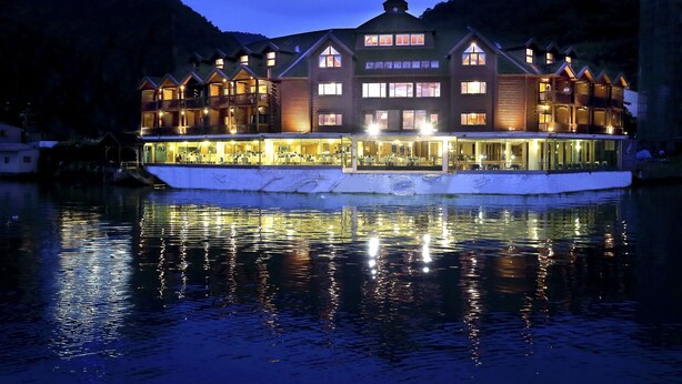A waterfront hotel with multiple balconies and large windows, reflecting on the water. - LEALEA GARDEN HOTEL SUN MOON LAKE (Yuchi)
