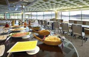 A buffet setup with various dishes and a scenic view of a lake through large windows. - LEALEA GARDEN HOTEL SUN MOON LAKE (Yuchi)