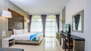 Una habitación de hotel moderna con cama, escritorio, televisor y un cesto de basura.
