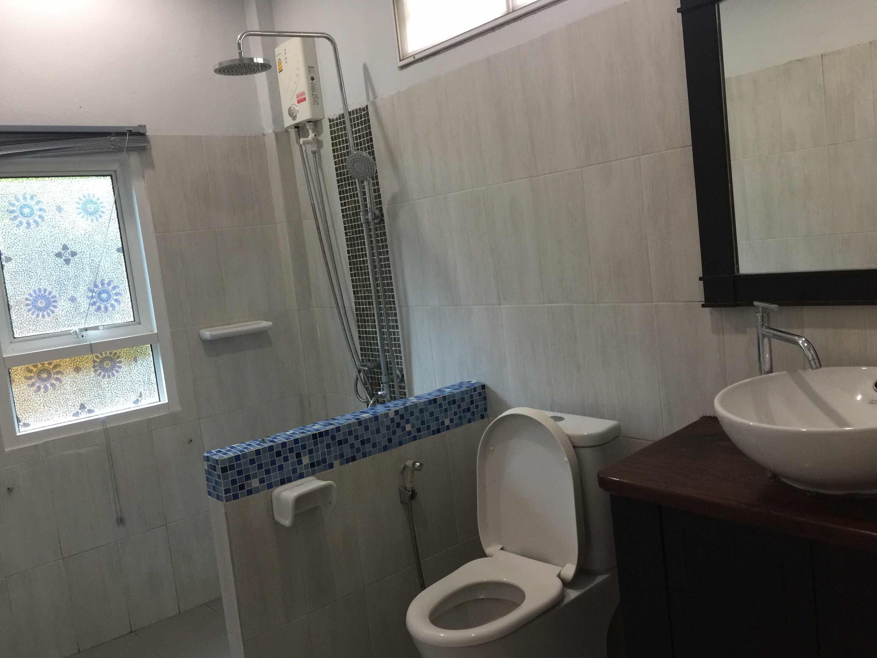 A bathroom with a shower, toilet, and sink.