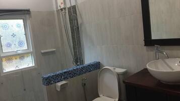 A bathroom with a shower, toilet, and sink.