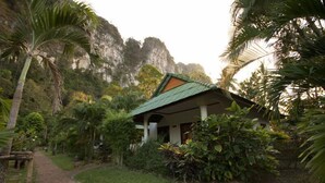 A small building with a green roof surrounded by lush greenery and a brick pathway. - Vipa Tropical Resort (Krabi)