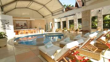 Una piscina al aire libre, sombrillas, tumbonas