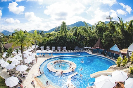 Una piscina al aire libre, sombrillas, sillones reclinables de piscina. Hotel Village Le Canton