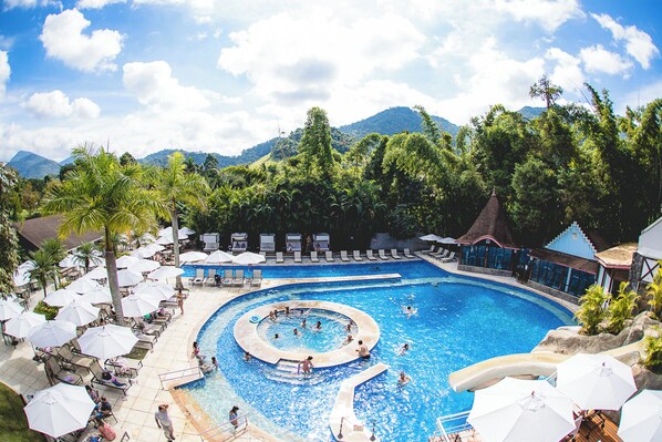 Alberca al aire libre, sombrillas en la alberca y camastros 