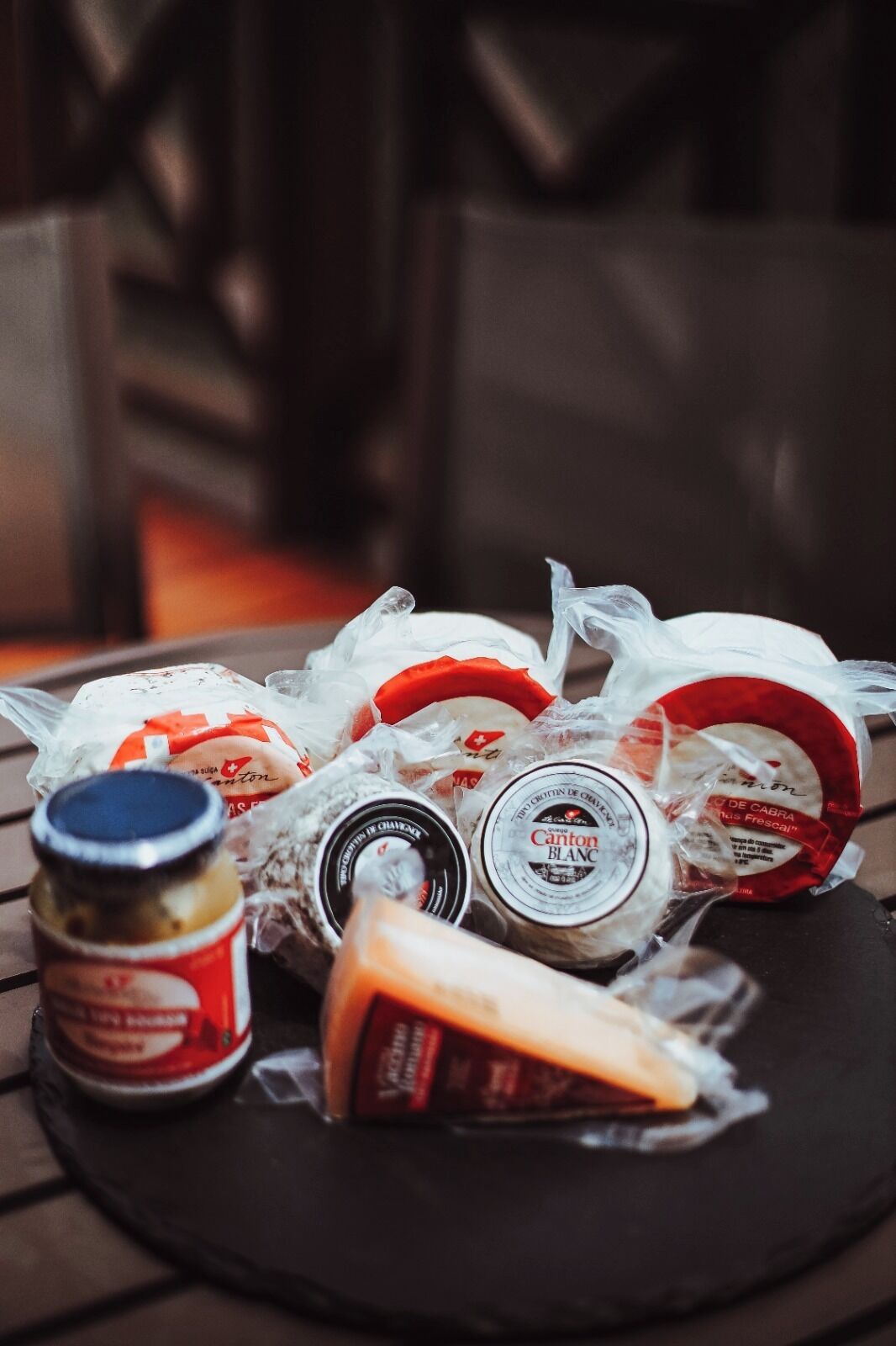 A table with various food items including cheese, bread, and condiments.