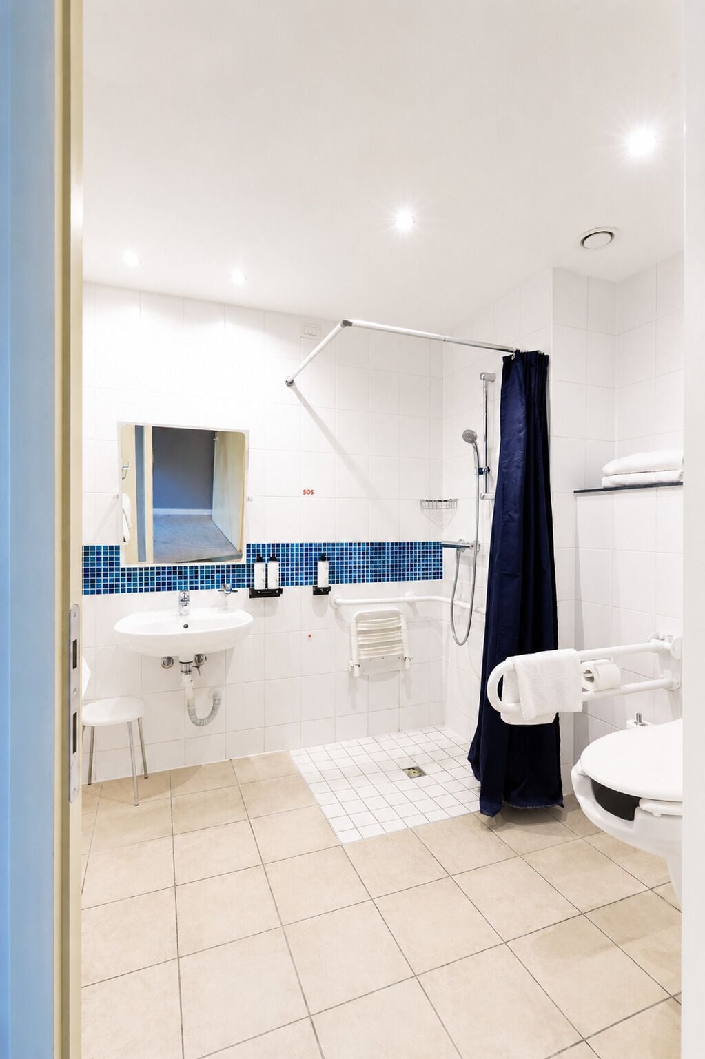 A bathroom with a shower, sink, and toilet.