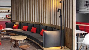 Un intérieur moderne avec un espace salon aux lignes courbes, des lambris en bois et une palette de couleurs noire et rouge.