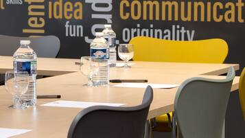 A conference room with a word cloud on the wall highlighting creativity, a table with water bottles, and modern chairs.