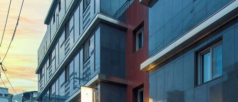 A modern building with a glass facade, a red awning, and a visible sign for 'Nansha Hotel'.