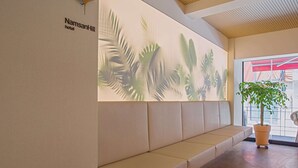 A reception area with a wall-mounted sign for NamsanHill hotel, a seating area, and a potted plant. - Namsan Hill Hotel (Seoul)