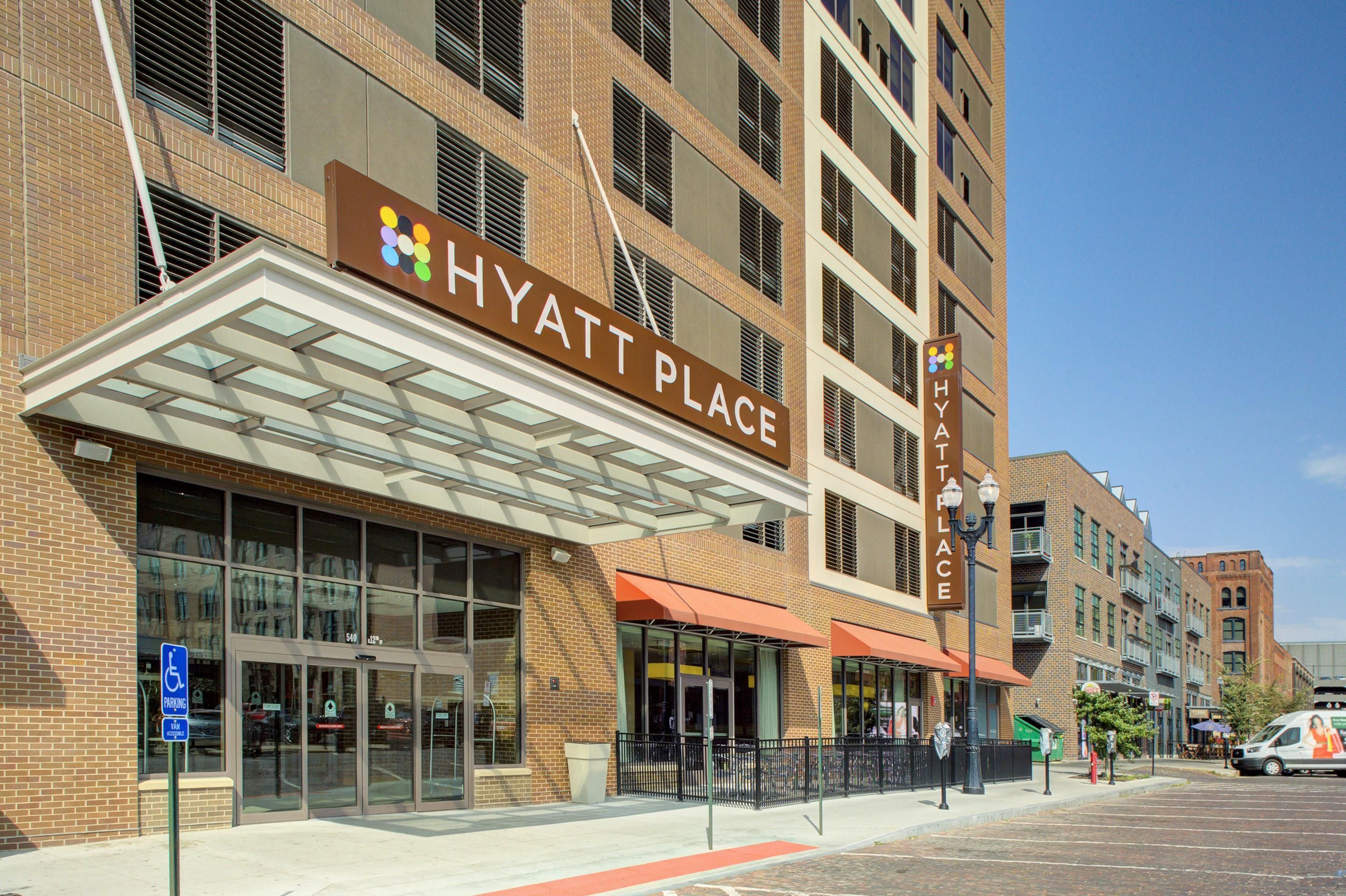 A brick building with a glass entrance and a sign reading 'HYATT PLACE'.