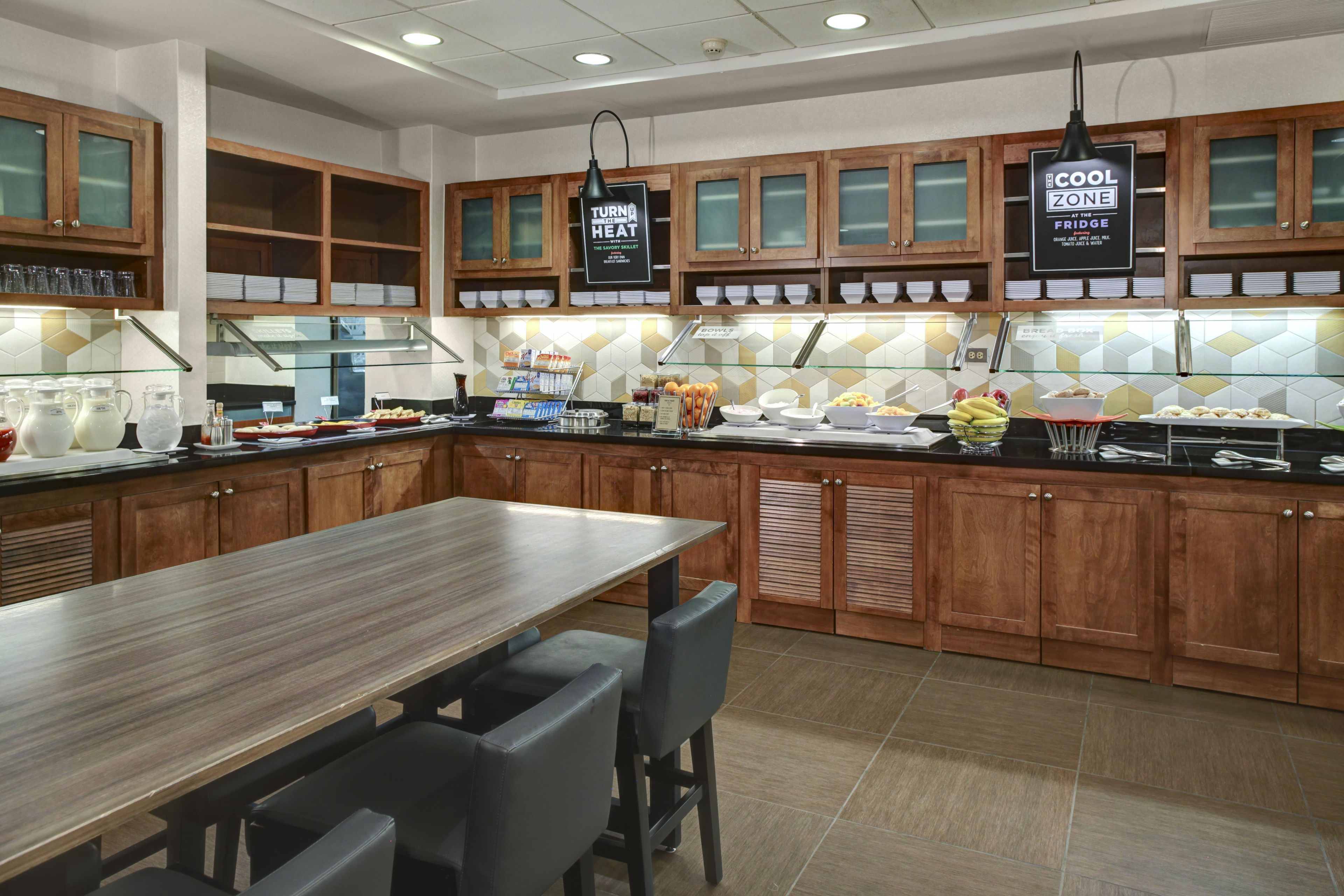 Una cocina moderna con armarios de madera, una isla de acero inoxidable y una barra desayunadora.