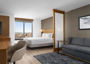 Une chambre d’hôtel avec un lit, un canapé, un bureau et une chaise.