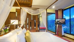 Un dormitorio con una cama grande, televisor y vista a la ciudad.