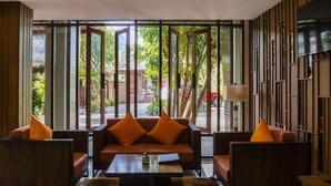 Una sala de estar moderna con sofá, sillones, una mesa de centro y televisor.