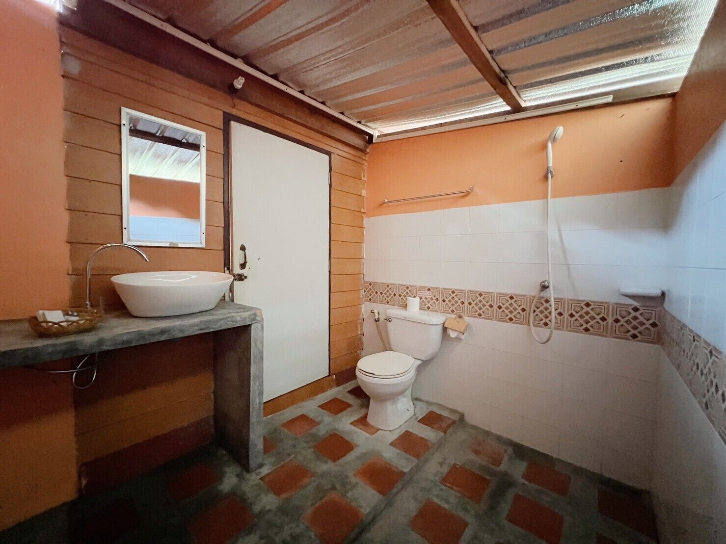 A small bathroom with a sink, toilet, and shower.