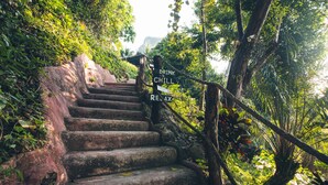A set of stone steps leading up a hill, surrounded by lush greenery and a sign that reads "DRINK CHILL RELAX." - Railay Garden View Resort (Krabi)