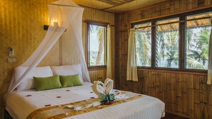 A bed with a canopy, green pillows, and a floral arrangement. - Railay Garden View Resort (Krabi)