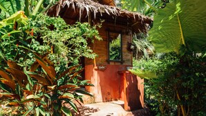 A rustic wooden hut with a thatched roof, surrounded by lush tropical vegetation. - Railay Garden View Resort (Krabi)