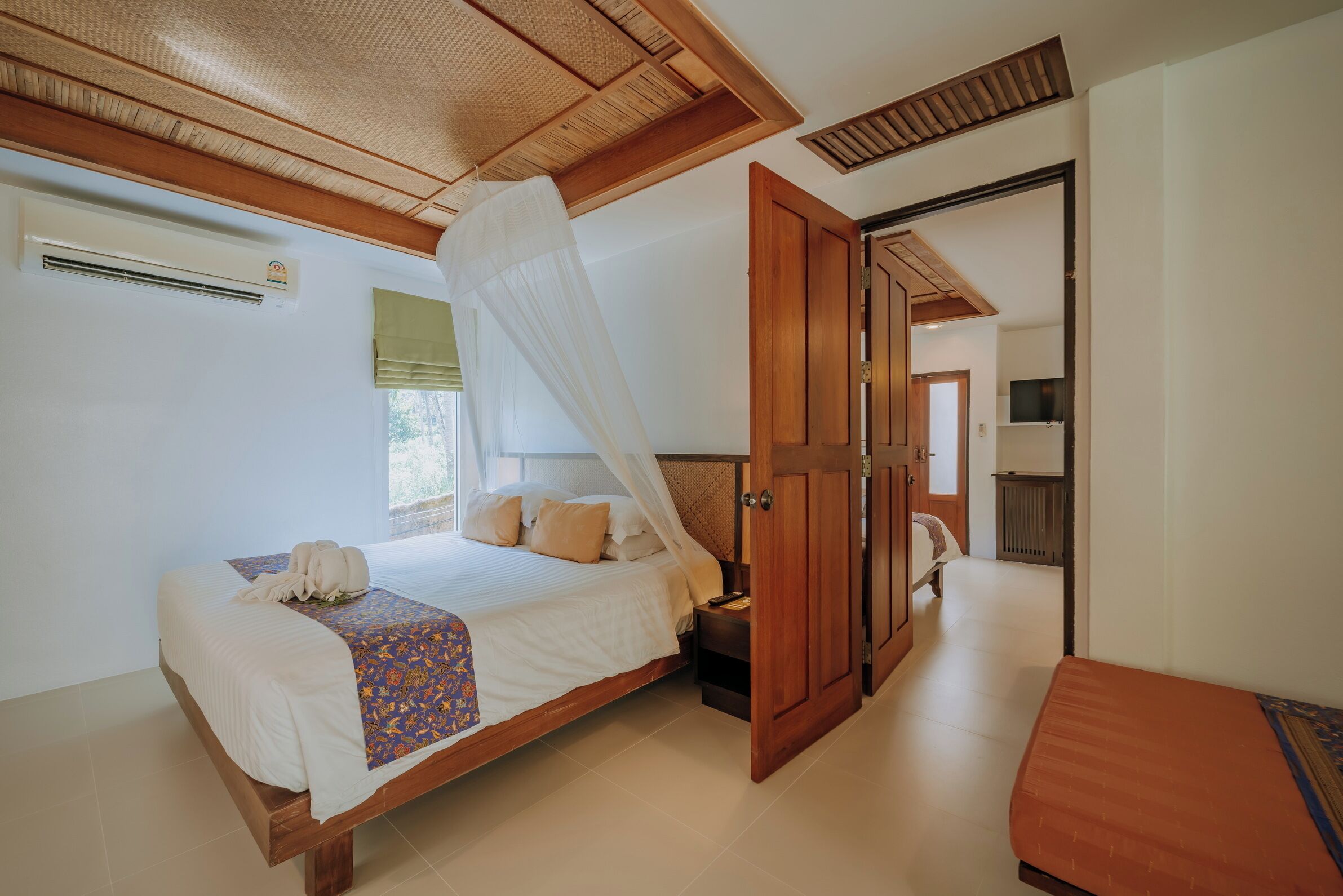 Un dormitorio con cama, mesita de noche, armario y ventana con vistas.