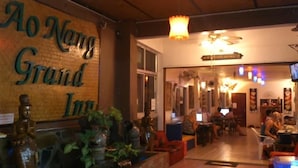 A cozy interior of a hotel with a wooden sign reading "Ao Nang Grand Inn". - Aonang Grand Inn (Krabi)